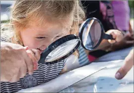  ?? NICK WAGNER / AMERICAN-STATESMAN 2017 ?? Charlotte Zirkle, 4, uses a magnifying glass to look at her fingerprin­ts during Austin Museum Day.