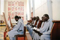  ??  ?? The monks read during the mass inside the church of the Abbey of Keur Moussa, in Senegal. — AFP photos