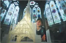  ?? VICTORIA JONES VIA ASSOCIATED PRESS ?? A curator looks at a model of Notre Dame de Paris during a preview for the Notre Dame de Paris, The Augmented Exhibition at Westminste­r Abbey in London on Feb 6.