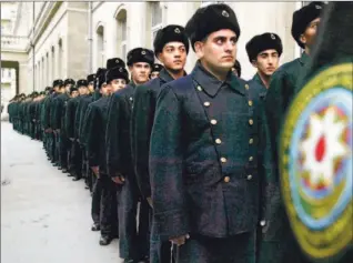  ?? SHAKH AIVAZOV/ AP ?? Azeri naval academy cadets stand in line to enter the polling station in Baku, Azerbaijan, yesterday. Early poll results have the ruling Yeni Azerbaijan Party winning nearly half the seats in parliament.