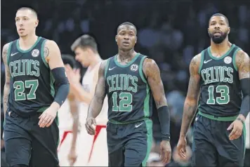  ?? Michael Dwyer / Associated Press ?? The Boston Celtics’ Daniel Theis, left, Terry Rozier, center, and Marcus Morris on Feb. 9 in Boston. Boston was the favorite to be the top team in the East but is currently in third place.