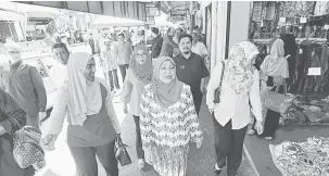  ?? — Gambar Bernama ?? ANANG NEMPAYA ANAK: Rohani (mua, tengah) begulai enggau bala bukai ngabas Bazar Indu 1Malaysia di Lorong Sempit ba Alor Setar, Kedah kemari.