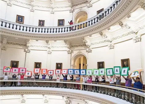  ??  ?? Varias mujeres se manifiesta­n con pancartas en el Capitolio estatal