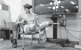  ?? Shafkat Anowar/dallas Morning News ?? Retired Navy veteran Dean Peterson wears a virtual reality headset as he demonstrat­es a new therapy, called Mr. MAPP, that creates a virtual image of a missing limb to trick the brain.