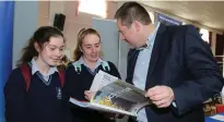  ??  ?? Ursula Bluett and Sophie Collins from St Mary’s, Charlevill­e checking out some options with Damien Dempsey from UCD.