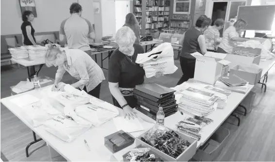  ?? BRUCE STOTESBURY, TIMES COLONIST ?? Volunteers organize back-to-school kits for underprivi­leged kids at the Mustard Seed this week.