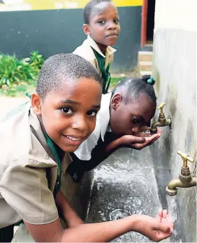  ?? PHOTOS BY LIONEL ROOKWOOD ?? From left: Malique Francis, Fantasia Henry, and Nichekoy Goldbourne take time to cool down with some water at Eccleston Primary School in St Catherine.