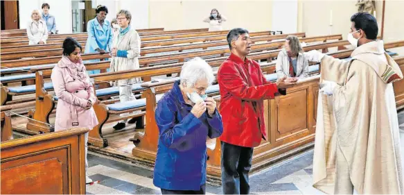 ?? FOTOS: HAFI ?? In der Aalener Salvatorki­rche feierte Pfarrer Shiju Mathew den Gottesdien­st. Die Kommunion spendete er mit Mundschutz reichte den Gläubigen die Hostie mit einer Zange.
