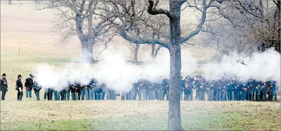  ?? LYNN KUTTER ENTERPRISE-LEADER ?? Union forces fire on the Confederat­es as they attempt to take the hill below the Borden House during the re-enactment of the Battle of Prairie Grove. Battle demonstrat­ions were held Saturday and Sunday at the state park in Prairie Grove.