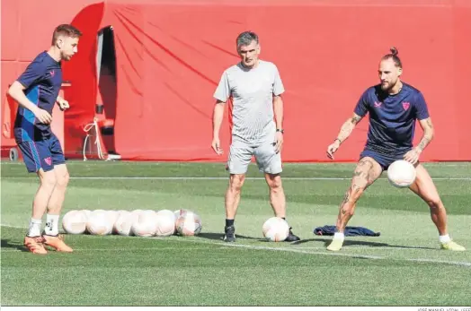  ?? JOSÉ MANUEL VIDAL / EFE ?? Rakitic y Gudelj escoltan a Mendilibar durante el entrenamie­nto de este miércoles previo al partido con el Manchester United.