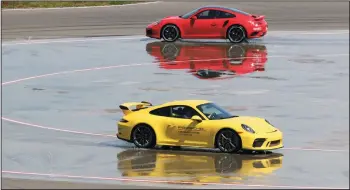  ?? MYUNG J. CHUN/LOS ANGELES TIMES ?? Drivers negotiate the Low-Friction Circle at the Porsche Experience Center in Los Angeles on April 10. This course allows drivers to experience under and oversteer. The 53-acre facility is open to the public even if you don’t own a Porsche.