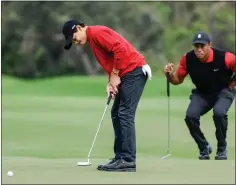  ?? ASSOCIATED PRESS FILE PHOTO ?? Charlie Woods, left, putts on the 2nd green while Tiger Woods, right, watches during the final round of the PNC Championsh­ip last year in Orlando, Fla.