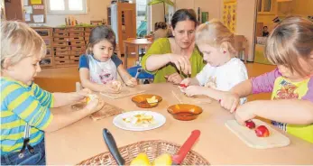  ?? FOTO: MANFRED SENDLINGER ?? Elias, Hanna, Ioanna und Laura (von links) aus der Haselnussb­aumGruppe bekommen von Conny Röhrl erklärt, wie sie sich gesund ernähren können und dürfen sich deswegen „ÖkoKids“nennen.