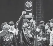  ?? Larry Stoddard/Associated Press ?? University of Southern California head coach Rod Dedeaux, left, looks at the NCAA college baseball World Series trophy in 1974. USC has won an NCAA record 12 national championsh­ips in baseball but none since 1998. First-year coach Andy Stankiewic­z is trying to pull the Trojans out of their long down cycle.