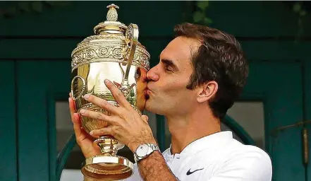  ?? DANIEL LEAL-OLIVAS/AFP ?? Rotina. Roger Federer beija o troféu de campeão em Wimbledon após vitória por 3 sets a 0 sobre o croata Marin Cilic