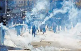  ?? REUTERS ?? Palestinia­n demonstrat­ors react to tear gas fired by Israeli troops during clashes at a protest against US President Donald Trump's decision to recognise Jerusalem as the capital of Israel.