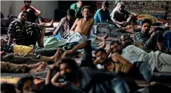  ?? Reuters ?? Daily wage workers and homeless people watch television inside a government­run night shelter in the old quarters of Delhi on Tuesday. —