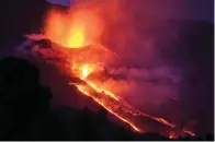  ?? The Associated Press ?? Lava flows from a volcano on the Canary island of La Palma, Spain, on Saturday. The new fissure is the third to crack open since the Cumbre Vieja crater erupted on Sept. 19.