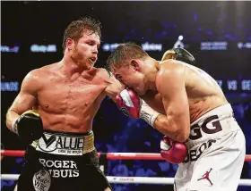  ?? Al Bello / Getty Images ?? ‘Canelo’ Álvarez (izq.) lanza un golpe de izquierda frente a Gennady Golovkin en el combate que el púgil mexicano ganó por puntos frente al experiment­ado boxeador kazajo en otra decisión controvert­ida en Nevada.