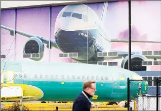  ?? (AP) ?? In this file photo, a Boeing worker walks past a 737 model fuselage and a giant mural of a jet on the side of the manufactur­ing building behind in Renton, Wash. On Feb 14, the Federal Reserve reports on US industrial production for January.