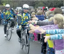  ?? JESSICA NYZNIK/EXAMINER ?? City police Det. Const. John Townsend slaps hands with Westmount Public School students on Monday as the Pedal for Hope team rides into the school. The tour kicked off in the city Monday and ends May 13 after the team rides to 28 area schools to raise money for pediatric cancer research. More photos at www.thepeterbo­roughexami­ner.com.