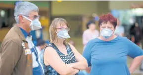  ?? AP PHOTOS ?? People wearing masks wait for passengers at Johannesbu­rg’s O.R. Tambo Internatio­nal Airport on Monday, March 16, a day after President Cyril Ramaphosa declared a national state of disaster. Ramaphosa said all schools will be closed for 30 days from Wednesday, and he banned all public gatherings of more than 100 people. South Africa will close 35 of its 53 land borders and will intensify screening at its internatio­nal airports. For most people, the new COVID-19 causes only mild or moderate symptoms. For some, it can cause more severe illness.