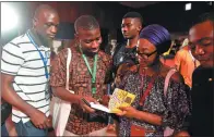  ?? PIUS UTOMI EKPEI / AGENCE FRANCE-PRESSE ?? Ayisha Osori (right), author of Love Does Not Win Election, signing autographs during the Ake Arts and Book Festival on Nov 17.