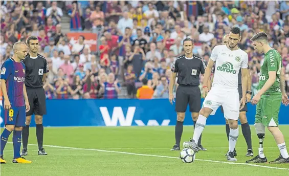  ?? EFE ?? Puntapié inicial. Helio Neto y Jackson Follmann, el arquero que sufrió la amputación de parte de su pierna, dan inicio al partido. Iniesta mira.