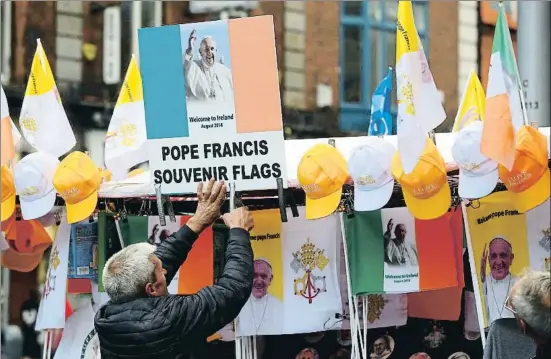  ?? HANNAH MCKAY / REUTERS ?? Un hombre vende banderas y gorras para dar la bienvenida al Papa, en Dublín