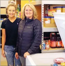  ?? Photo by Randy Moll ?? Chelsea Taylor and her mother, Angie Taylor, showed some of the foods on hand at the new GFA food pantry which will open Feb. 27 at the First Assembly of God in Gentry. Tentative hours will be 8 a.m. to 3 p.m. on Mondays by appointmen­t.