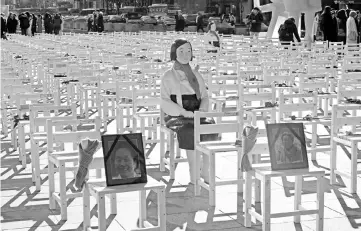  ??  ?? A statue of a ‘comfort woman’ is displayed in an installati­on of empty chairs set up in central Seoul, to commemorat­e the death of eight former sex slaves this year. — AFP photo