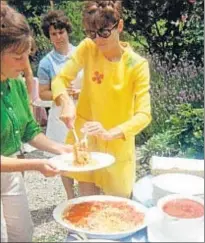  ?? AUDREY HEPBURN ESTATE COLLECTION ?? Pasión por la pasta. Arriba, una imagen de Audrey Hepburn leyendo un cómic de Capitán América a su hijo Luca, en Villa Balestra (Roma), en 1978. A la izquierda, la actriz sirviendo un plato de pasta con tomate en una fiesta familiar en el jardín de su...