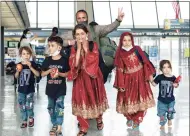  ?? Va., Friday. Jose Luis Magana / Associated Press ?? Families evacuated from Kabul, Afghanista­n, walk through the terminal before boarding a bus at Washington Dulles Internatio­nal Airport in Chantilly,