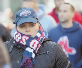  ??  ?? BRRR: Fans bundled up to fight off frigid temperatur­es and bitter winds at the home opener at Fenway Park.