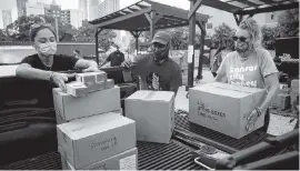  ?? MATIAS J. OCNER mocner@miamiheral­d.com ?? Volunteers load a vehicle with personal protective equipment during a drive-thru distributi­on event in Overtown on Saturday.