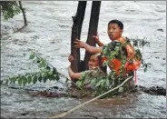  ?? QU HUI / FOR CHINA DAILY ?? A firefighte­r rescues a woman in Beijing’s Huairou district after heavy rain led to floods in the city’s suburbs.