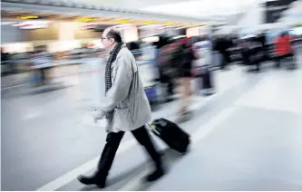  ?? CANADIAN PRESS FILES ?? A man carries his luggage at Pearson Internatio­nal Airport in Toronto. Air Canada and WestJet are facing a potential class action lawsuit after imposing checked baggage fees only days apart.