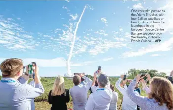  ?? — AFP ?? Obervers take picture as the Ariane 5 rocket, with four Galileo satellites on board, takes off from the launchpad in the European Space Centre (Europe spaceport) on Wednesday in Kourou, French Guiana.