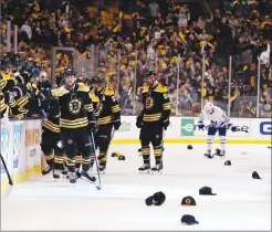  ?? Associated Press photo ?? As hats litter the ice, Boston Bruins' David Pastrnak is congratula­ted at the bench after scoring his third goal of the game during the third period of a win over the Toronto Maple Leafs in Game 2 of the first-round playoff series in Boston Saturday.