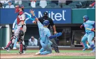  ?? Jeffrey McWhorter / Associated Press ?? The Rangers’ Isiah Kiner-Falefa scores on a go-ahead RBI single by Brock Holt as home plate umpire Brian O’Nora and Red Sox catcher Kevin Plawecki look on.