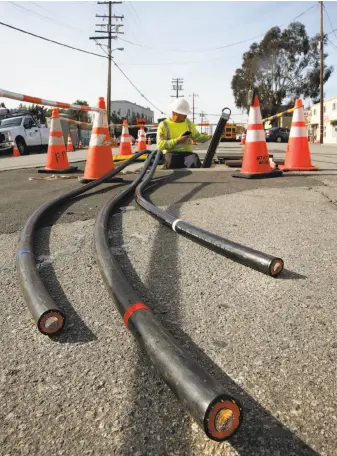  ?? Michael Macor / The Chronicle ?? Zach Braun with Pinnacle Power installs PG&E power lines undergroun­d along Old Country Road near Harbor Way in Belmont. PG&E often redirects its funds for undergroun­ding.