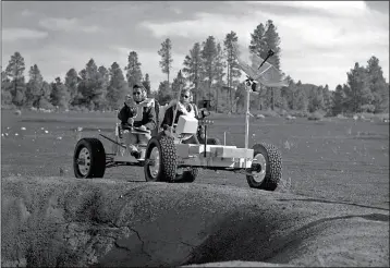  ?? U.S. GEOLOGICAL SURVEY ASTROGEOLO­GY SCIENCE CENTER VIA AP ?? THIS UNDATED PHOTO provided by the U.S. Geological Survey Astrogeolo­gy Science Center shows Apollo 15 astronauts Jim Irwin (left) and Dave Scott driving a prototype of a lunar rover in a volcanic cinder field east of Flagstaff. The rover, named Grover, now is on display at the science center.