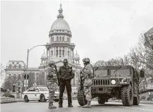  ?? Justin L. Fowler / Associated Press ?? Members of the Illinois National Guard and the Capitol Police are posted at a road closure Sunday near the Illinois State Capitol.