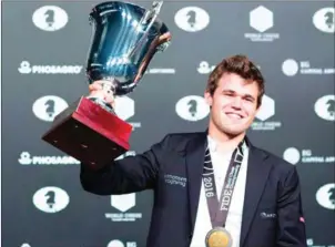  ?? EDUARDO MUNOZ ALVAREZ/AFP ?? Magnus Carlsen, Norwegian grandmaste­r holds the trophy during the closing ceremony of the World Chess Championsh­ip on December 1, 2016.