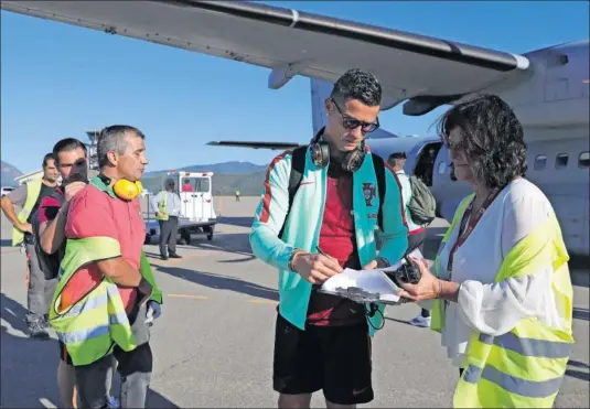  ??  ?? SOLICITADO. Cristiano firma un autógrafo a una empleada del aeropuerto de Lisboa tras regresar ayer de Andorra.
