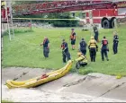  ?? The Associated Press ?? Milwaukee Fire Department Dive Rescue Team prepare a raft to enter a drainage ditch on Monday, in Milwaukee, Wis.