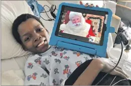  ?? UCLA Mattel Children’s Hospital ?? ARMONTE JOHNSON visits with Santa Claus via Zoom “from the North Pole” from his bed at UCLA Mattel Children’s Hospital on Christmas Eve.