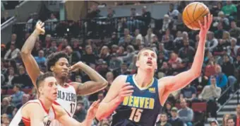  ??  ?? Nuggets center Nikola Jokic tries to score against the Trail Blazers during the first half of Friday night’s game in Portland, Ore. Jokic came into the game with season averages of 15.5 points, 10.4 rebounds and 4.4 assists. He was shooting 50.9...