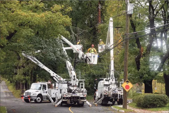  ?? H John Voorhees III / Hearst Connecticu­t Media ?? Crews work on downed power lines on South Street at Oakland Heights in Bethel on Wednesday. Power was out in multiple locations due to a storm that moved through the area overnight.