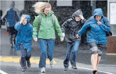  ?? Photo: KENT BLECHYNDEN/FAIRFAX NZ ?? On a mission: Pedestrian­s are blasted by driving rain in Wellington’s Feathersto­n St yesterday.